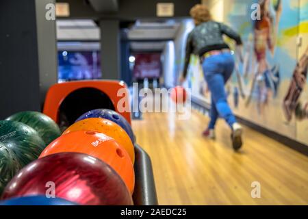 Woman throwing bowling ball on indoor bowling alley Stock Photo