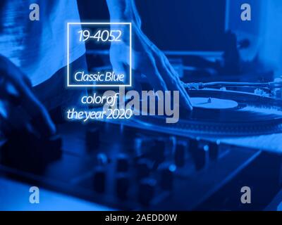 close up dj hand play music on turntable record setup , color of the 2020 year trend, classic blue tones Stock Photo