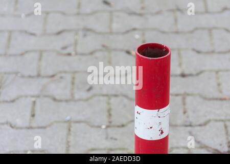Traffic pole on pavement for safety Area close up. Red and white striped road barrier. Metal pole to prevent cars from using path .for concept design Stock Photo