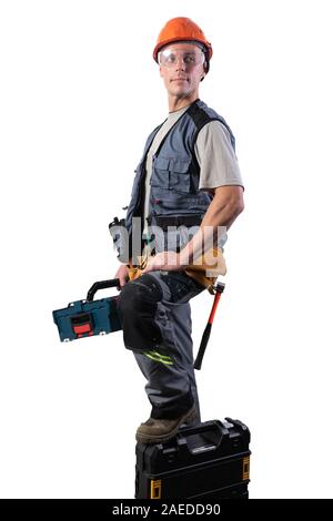 Builder with tools in cases. In a helmet and glasses, and unloading. Stock Photo