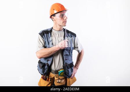 A builder in a helmet makes visual measurement with a marking pencil. Stock Photo