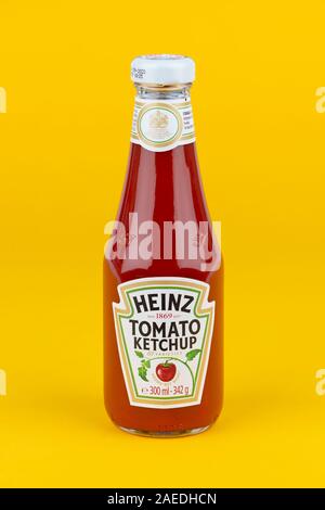 A bottle of Heinz Tomato Ketchup shot on a yellow background. Stock Photo