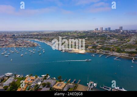 Yacht cruising through Newport Beach Peninsula with a city background Stock Photo