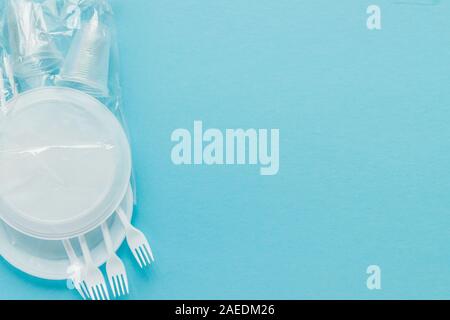 Plastic dishes on a blue background. Disposable tableware Stock Photo