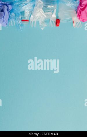 Top view of various kinds of disposable plastic waste on blue background, copy space Stock Photo
