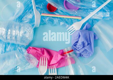 Top view of various kinds of disposable plastic waste on blue background, copy space Stock Photo