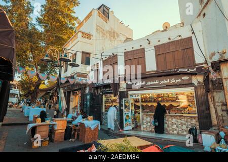 Women selling their products in front of a dates store next to the Souk Baab Makkah street market at the historic district Al Balad in Jeddah, KSA Stock Photo