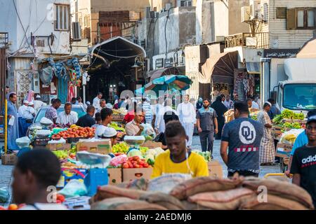 View of Arabic people bustling through the Souk Baab Makkah street market at the historic district Al Balad in Jeddah, KSA, Saudi Arabia Stock Photo