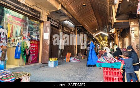 View of women sell textiles at the roofed section of the Souk Baab Makkah street market at the historic district Al Balad in Jeddah, KSA, Saudi Arabia Stock Photo