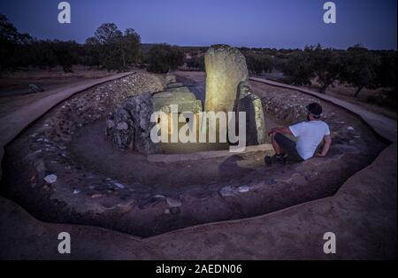 Visitor sat close Dolmen of Lacara at night. The biggest megalithic burial in Extremadura, Spain Stock Photo