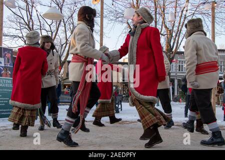 Longueuil, Québec, Canada - December 7, 2019: French Canadian Dancers in winter during a Christmas Market, Traditional Dance in circle, Arrow Sash Stock Photo