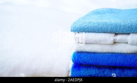 Stack of towels in blue and white, on white snow, isolated. Classic blue color of the year 2020. Stock Photo