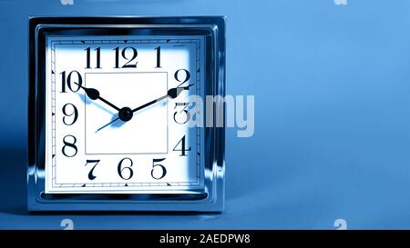 Christmas Party Holiday time, Black Friday Discount concept with metal silver clock on blue color background, isolated. Flat lay, top view, place for text. Classic blue color of the year 2020. Stock Photo