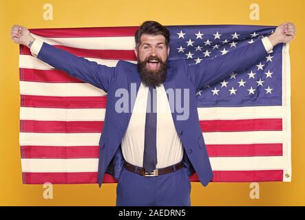 American by birth. Rebel by choice. Businessman concept. Confident businessman handsome bearded man in formal suit hold flag USA. Successful businessman well groomed appearance. Business people. Stock Photo