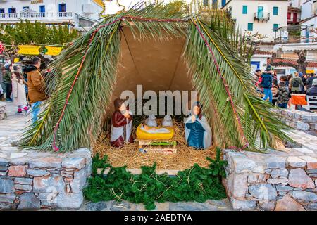 Nativity Manger placed by the picturesque port of Skopelos island during the Christmas tree lightning ceremony. Christmas decoration in Skopelos. Stock Photo