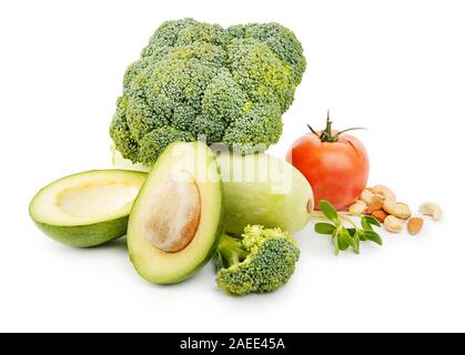 Heap of fresh vegetables and nuts with broccoli, avocado, tomato, squash and greens on white background Stock Photo