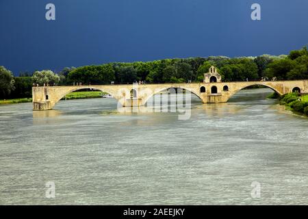 The Pont d'Avignon spanning part way across the Rhone River as a storm approaches in Avignon France Stock Photo