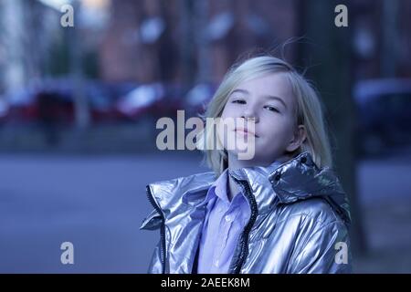 Closeup half-turned portrait of blonde little girl in modern grey jacket Stock Photo