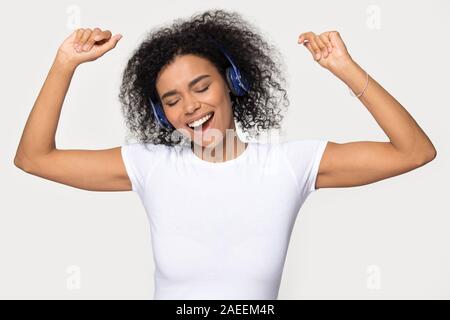 Happy African American woman in headphones dancing, enjoying music Stock Photo