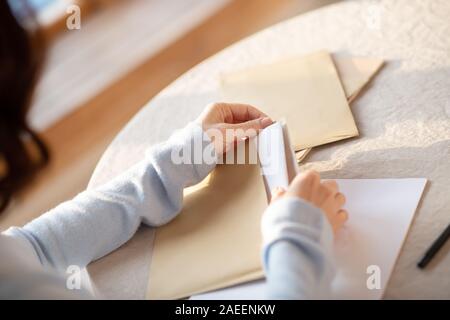 Woman in grey sweater opening the envelope