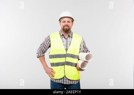 Young cheerful engineer or foreman in protective helmet and workwear Stock Photo