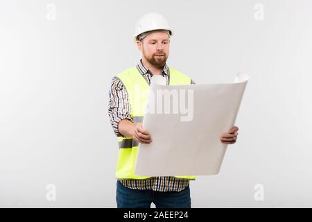 Successful engineer or foreman in helmet and workwear holding blueprint Stock Photo