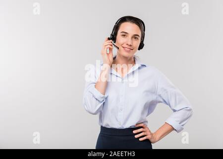 Young smiling businesswoman in headset consulting clients on the phone Stock Photo