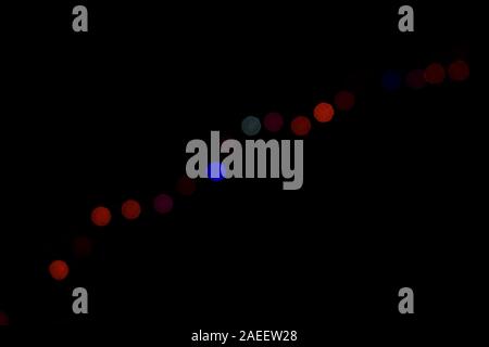 Blurred background, bright colored light bulbs on dark background Stock Photo
