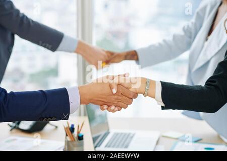 Hands of business executives shaking hands after successful business meeting in office Stock Photo