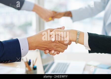 Close-up image of entrepreneurs shaking hands and entroducing themselves before discussing important issues at meeting Stock Photo