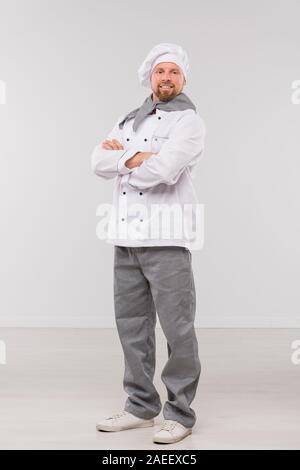 Successful young male chef with his arms crossed by chest looking at you Stock Photo