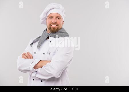 Young smiling professional chef of restaurant with his arms crossed by chest Stock Photo