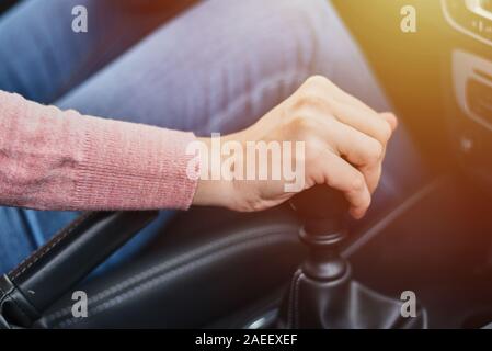 Woman driving car. Female hand change speed on manual gearbox Stock Photo