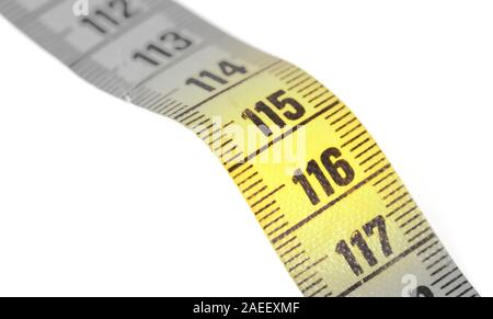 Close-up of a yellow measuring tape isolated on white - 116 - Selective focus Stock Photo