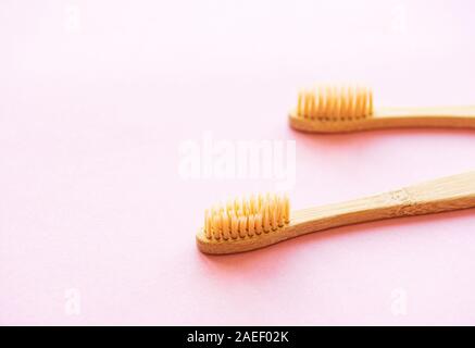Bamboo toothbrushes on light pink background. Zero waste and use biodegradable and recyclable material concept. Flat lay. Stock Photo