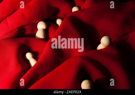 shipwreck concept. wooden pawns swallowed by red waves Stock Photo