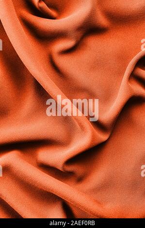 Abstract fabric texture. Trend shade of orange-red color. Top view. Copy space. Stock Photo