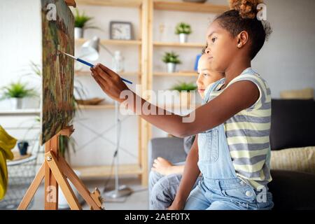 Cute children girl and boy painting together. Education, art, fun and creativity concept. Stock Photo