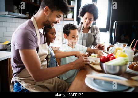 Happy family in the kitchen having fun and cooking together. Healthy food at home. Stock Photo