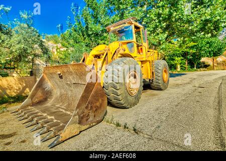 Side view of yellow bulldozer on wheels for building work on a road. Work in progress, industrial machine. Stock Photo