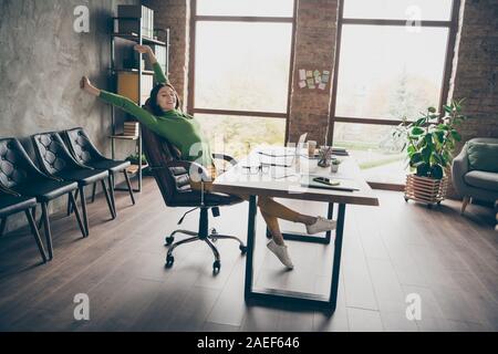 Full size profile photo of funny brunette business lady notebook table have fun little break raise hands sit chair wear specs green turtleneck yellow Stock Photo