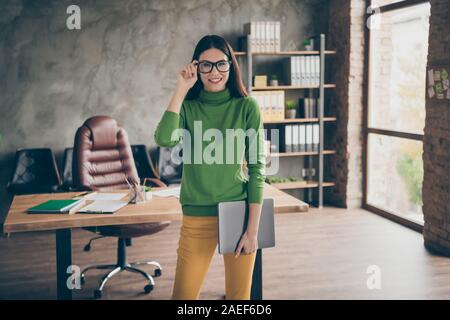 Portrait of her she nice attractive pretty cheerful cheery content girl broker agent leader partner holding in hands laptop touching specs at modern Stock Photo