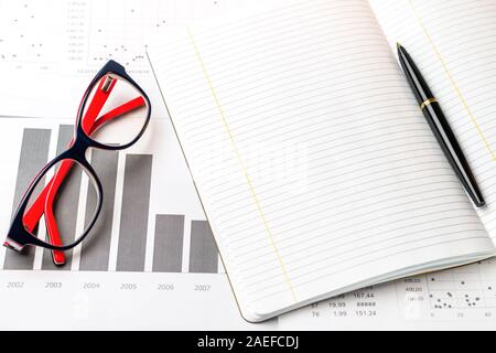 a line writing notebook and a black pen with a modern pair of glasses Stock Photo
