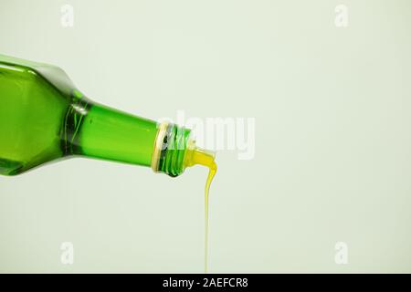 Oil pouring out of a glass bottle. Fine vegetable oil, close-up view Stock Photo