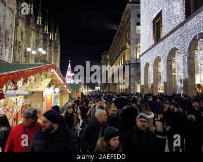 Milan, Italy - December 7, 2019 Blurred people visit the traditional Christmas Market at the Corso Vittorio Emanuele next to the Duomo in Milan Stock Photo