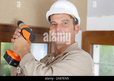 happy man holding a rotary drill Stock Photo