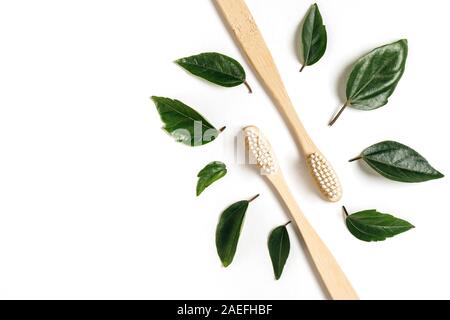 Zero waste. Two wooden bamboo eco friendly toothbrushes and green leaf on white background. Dental care and Eco friendly and reuse concept. Flat lay, Stock Photo