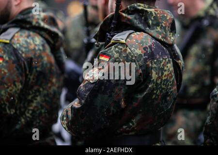 Details with the uniform and the flag on it of a German soldier taking part at the Romanian National Day military parade. Stock Photo