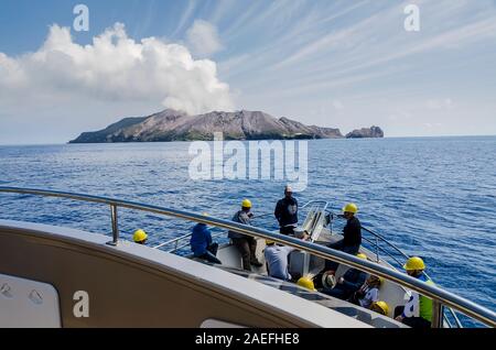 tourist boat going towards the White Island, with the billowing smoke coming out of the active volcano Stock Photo