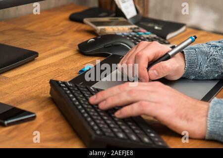 Close up of male hands during using a graphic tablet Stock Photo